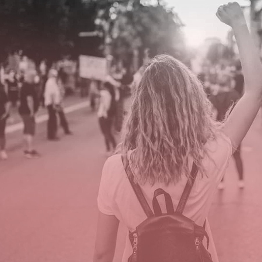 Una mujer con el puño arriba en una marcha de mujeres.